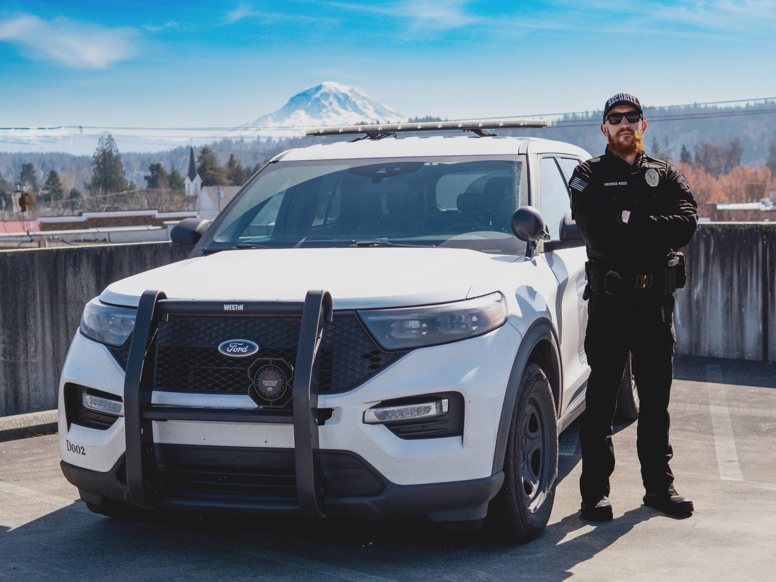 Diligence Security Patrol Officer beside a marked vehicle with a Washington mountain backdrop